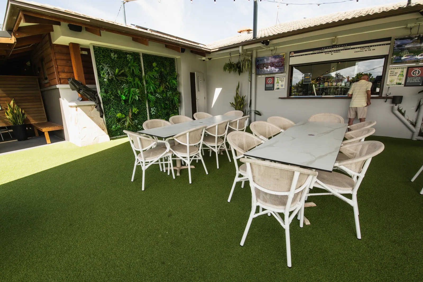Shaded outdoor dining tables in the beer garden by the greens