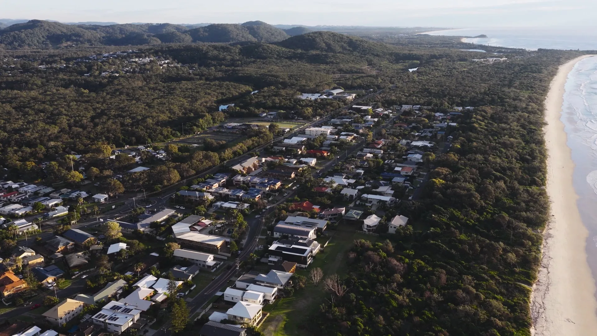 Aerial view over Pottsville village, the creek and the beach stretching up the Tweed Coast