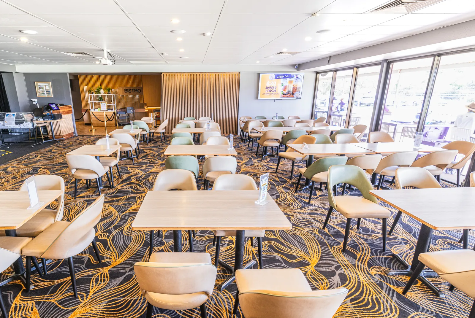 The restaurant set with tables and chairs, looking towards the bistro counter