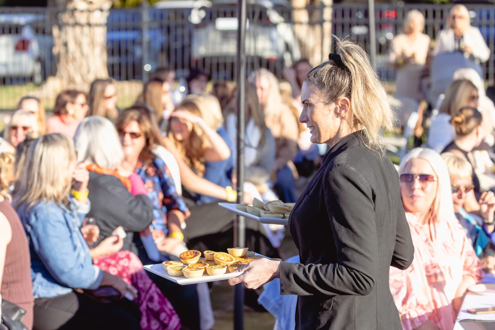 A Pottsville Sports staff member carrying a tray of food out to guests at a club event